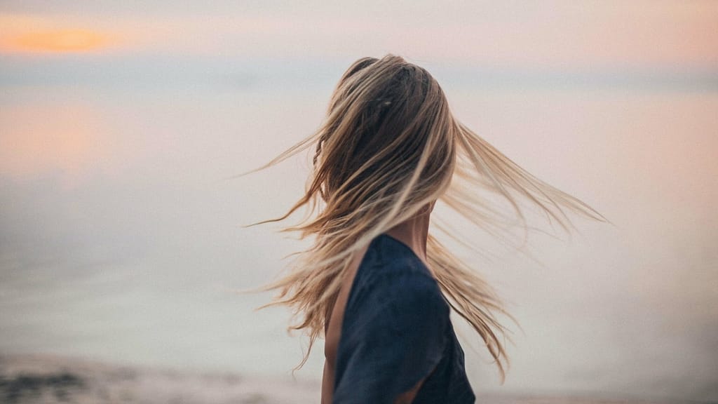 Image: A woman turning around to face a body of water, symbolic of facing rejection