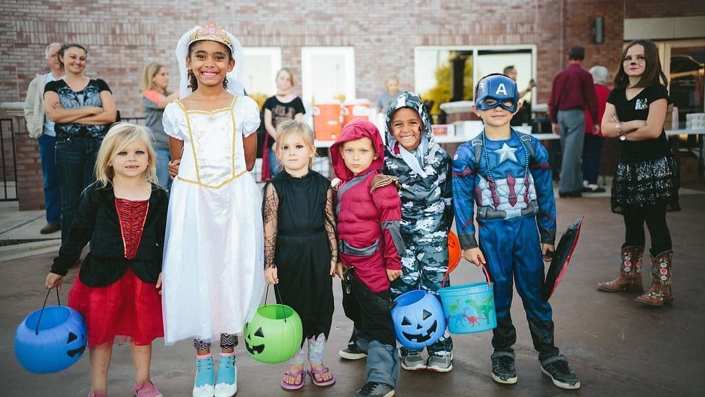Image: A group of children in their trick or treat for UNICEF costumes. A witch, princess, vampire, and three superheroes.