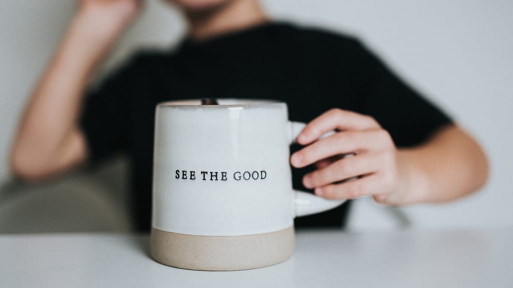Image: A mug with "see the good" engraved on it, advocating for a positive worldview.