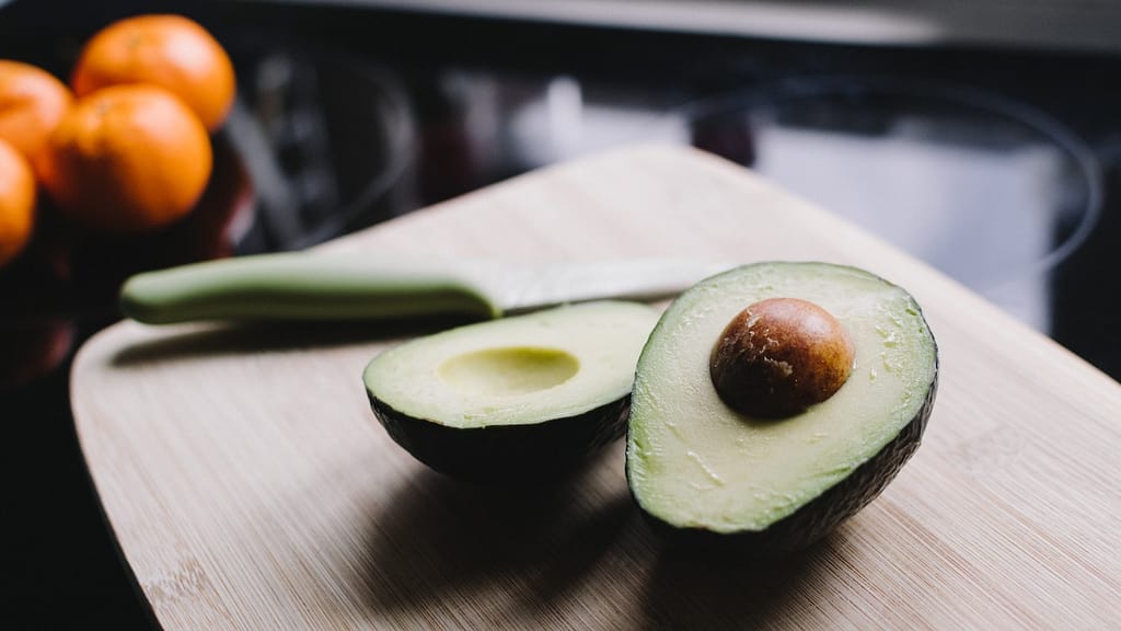 Image: An avocado cut in half, sitting on a cutting board