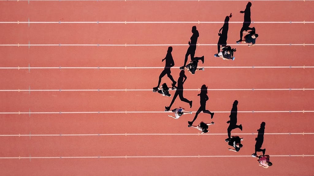 Image: Runners on a track, everyone starting at a different place, representing how everyone has a story that impacts their position in life. 