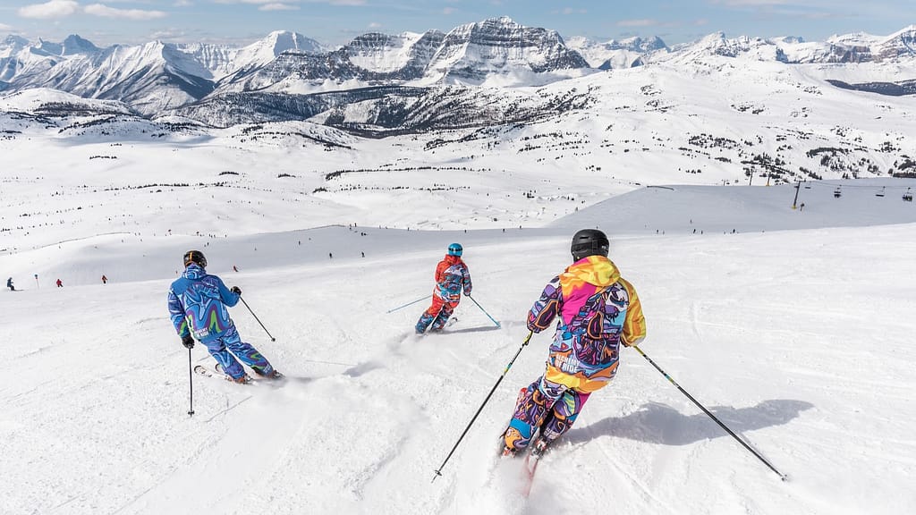 Image: Three skiiers making their way down a ski slope like champion Lindsey Vonn. 