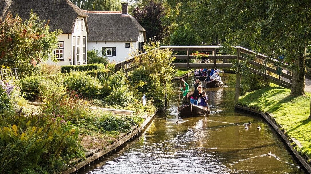 Image: People on boats going down a canal in Giethoorn