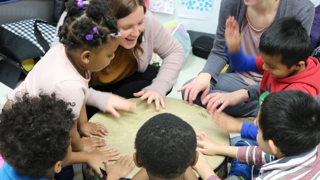 Image: Students and instructors from Voices Together sitting around a table