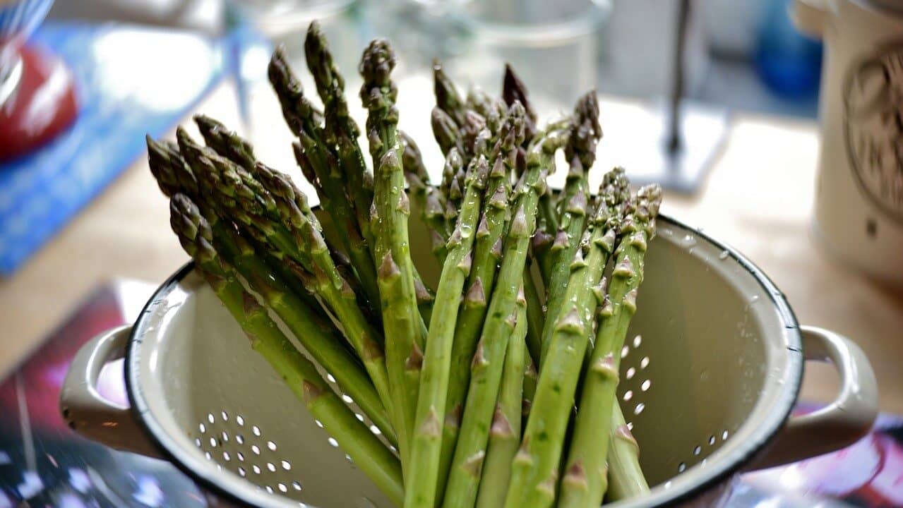 Image: a bunch of freshly washed asparagus in a strainer