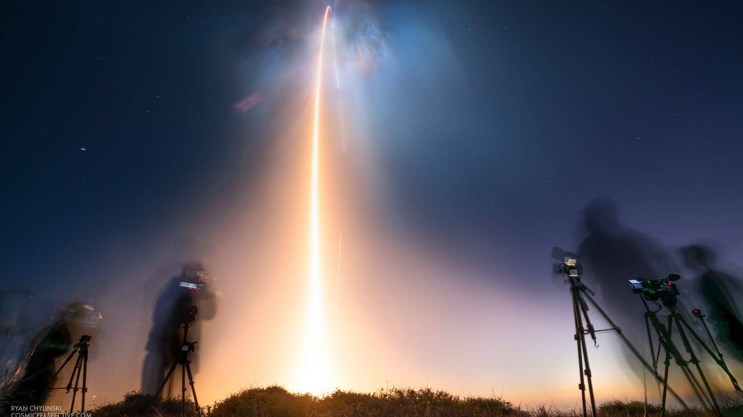 Image: spacex launch streak of light on a dark cloudy sky