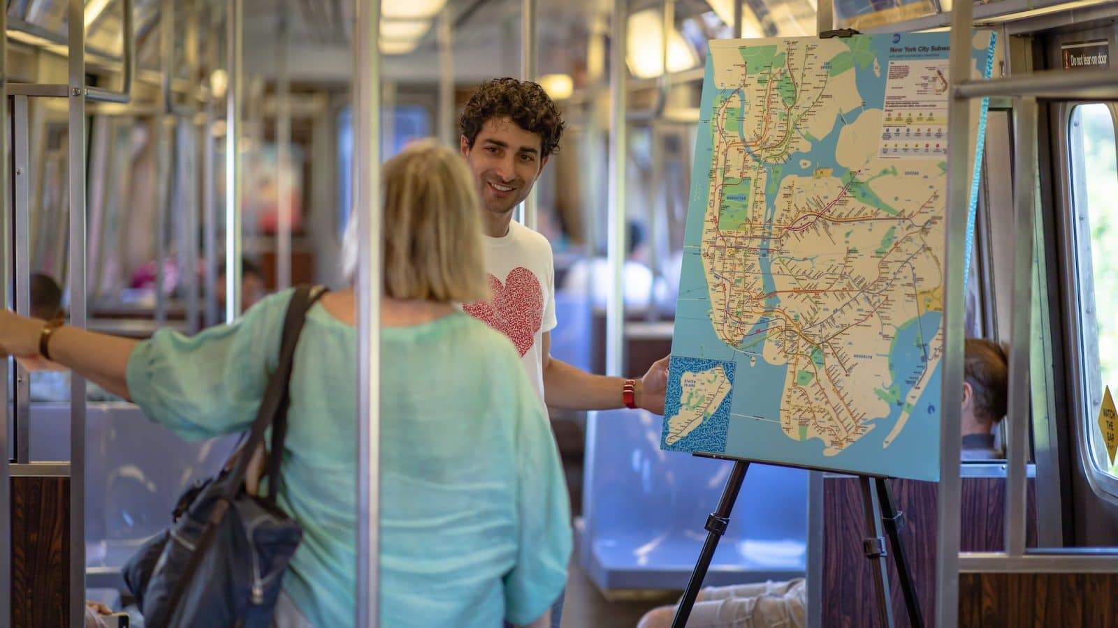 Image: Marco Santini on the NYC subway asking a woman what she loves about New York City