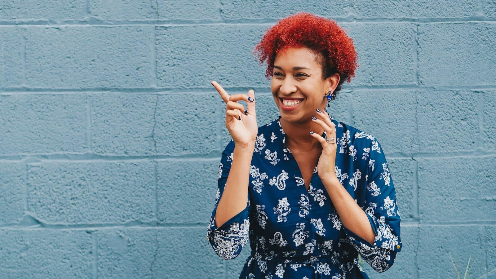 woman smiling while pointing on her right side