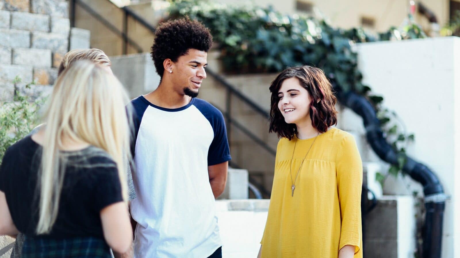 women and man talking outside the building