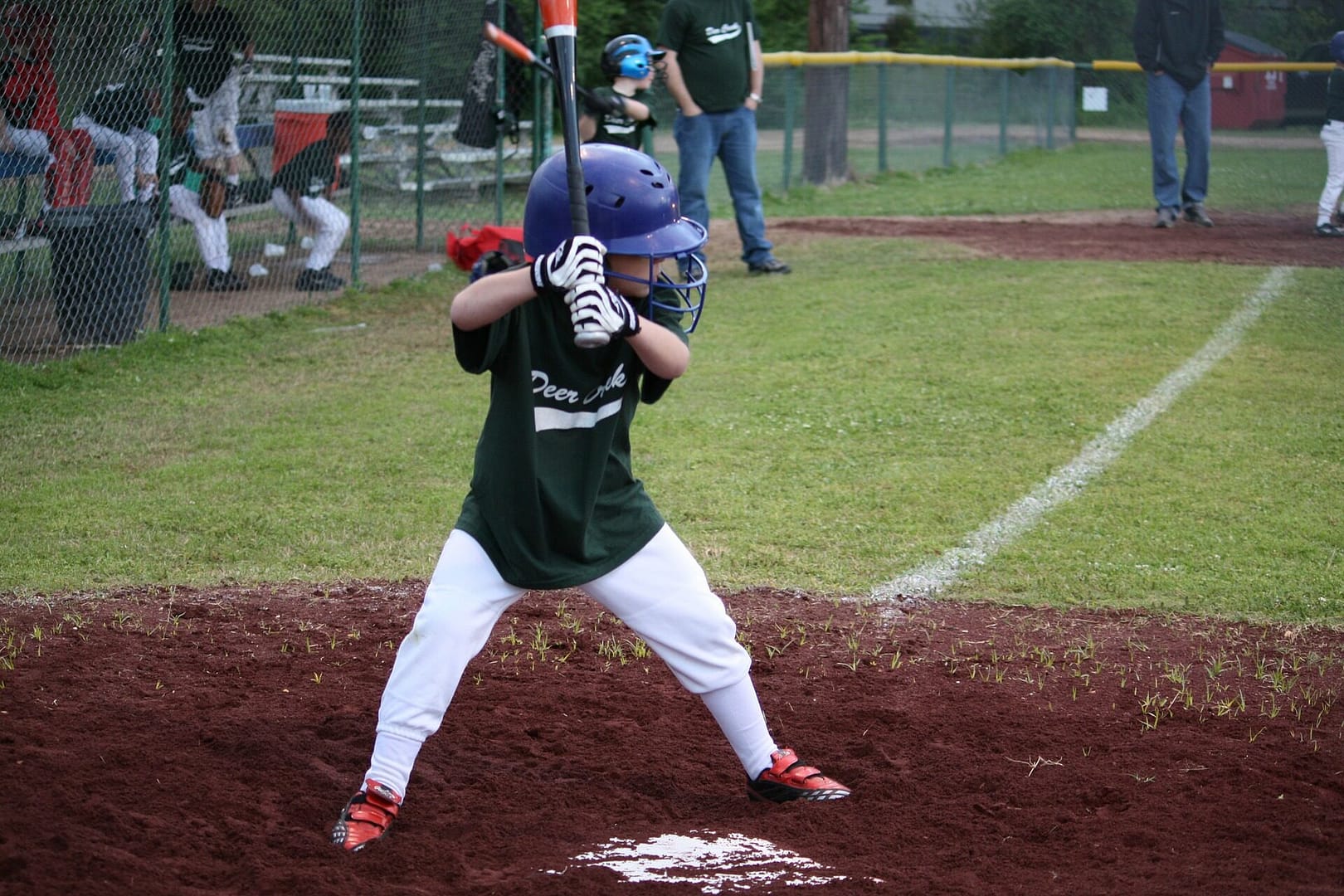 Image: a child steps up to the baseball plate ready to swing the bat