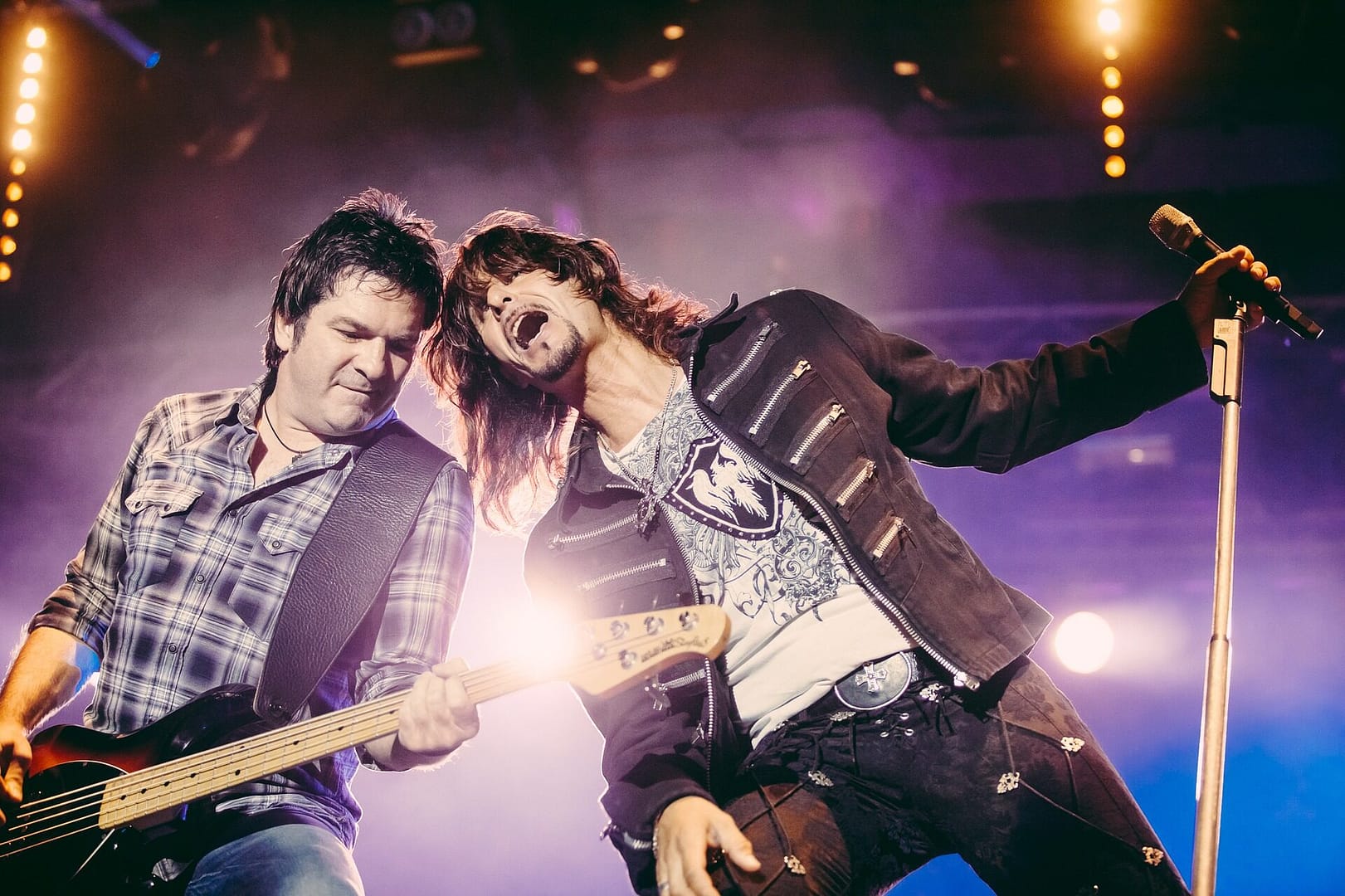 Image: Musicians singing and playing guitar on stage