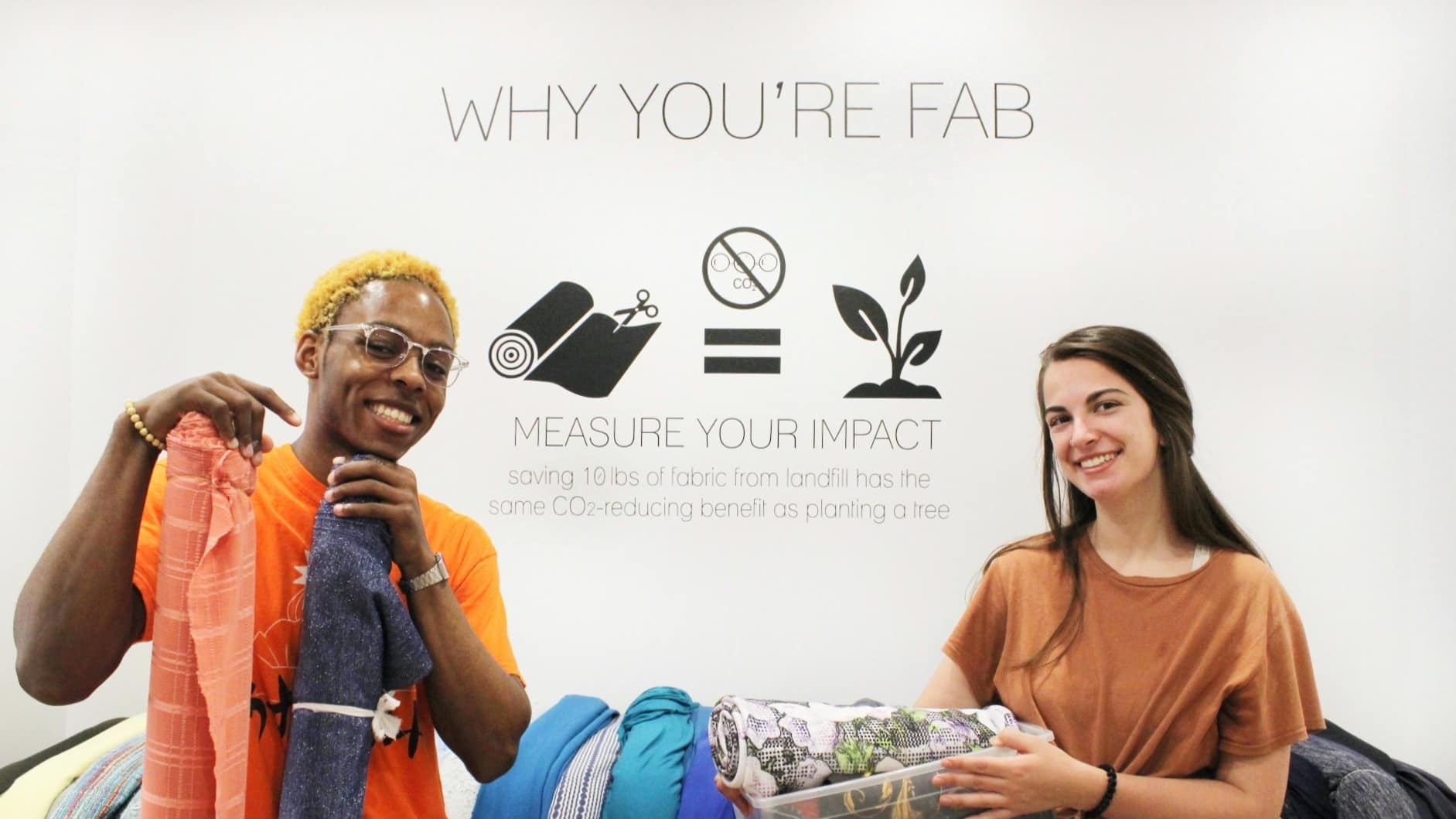 Image: FABSCRAP Volunteers holding some of their fabric that will be mended, repurposed, or recycled