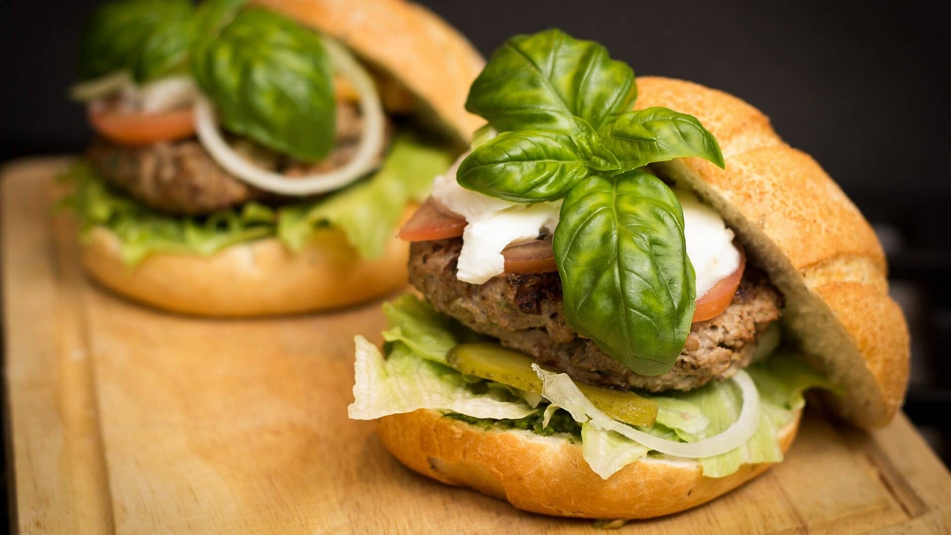Image: A Hamburger with a huge basil sprig on it.