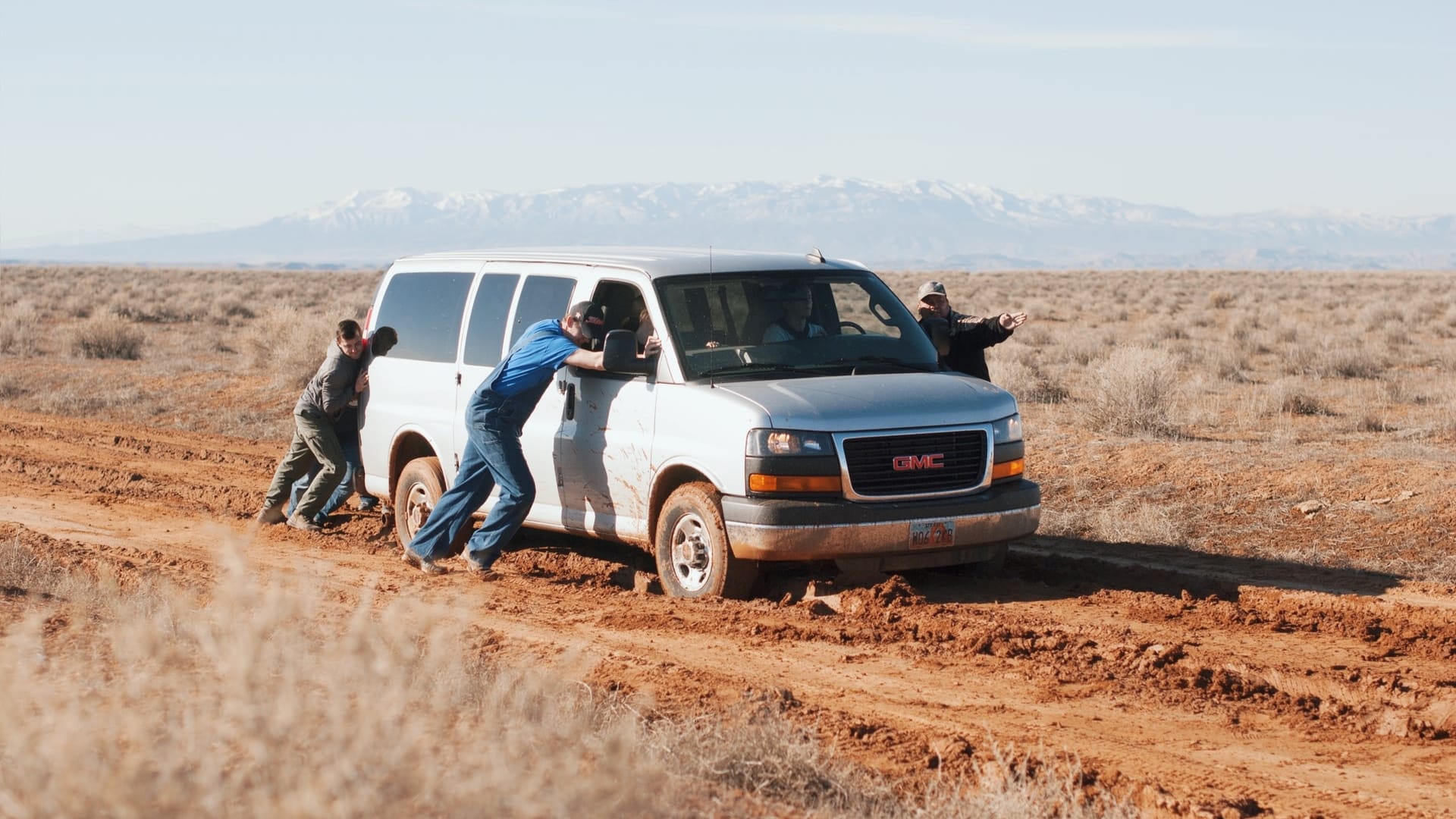 Image: Men pushing a van which is stuck in the mud. A metaphor for being stuck in life.