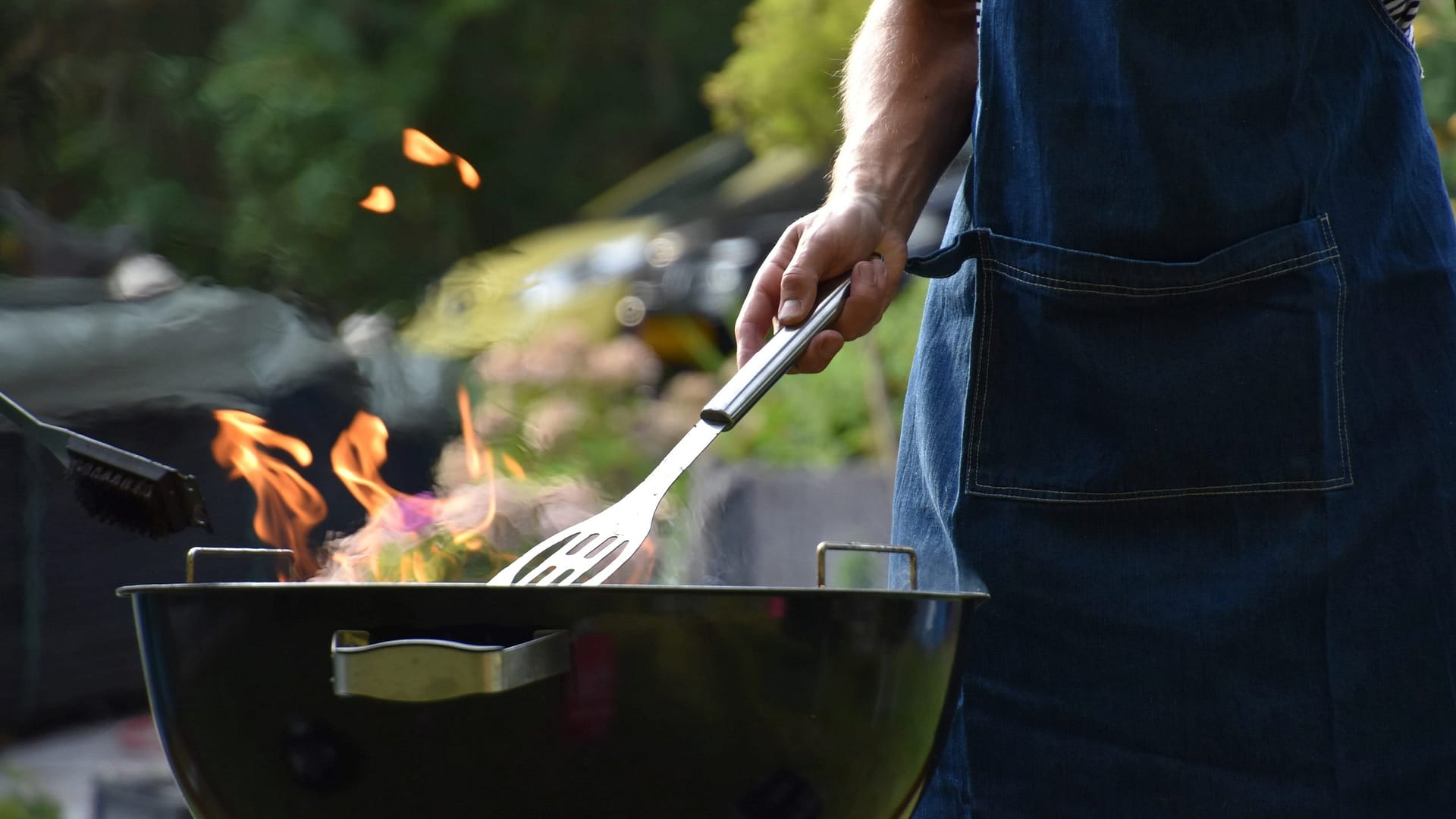 Image: A person barbecuing in their backyard using fruit pulp logs.