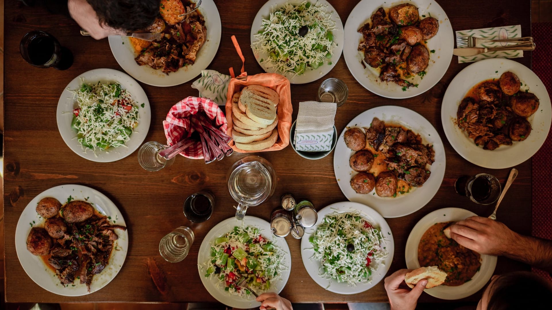 Image: A family dinner, with ten plates full of diverse kinds of food