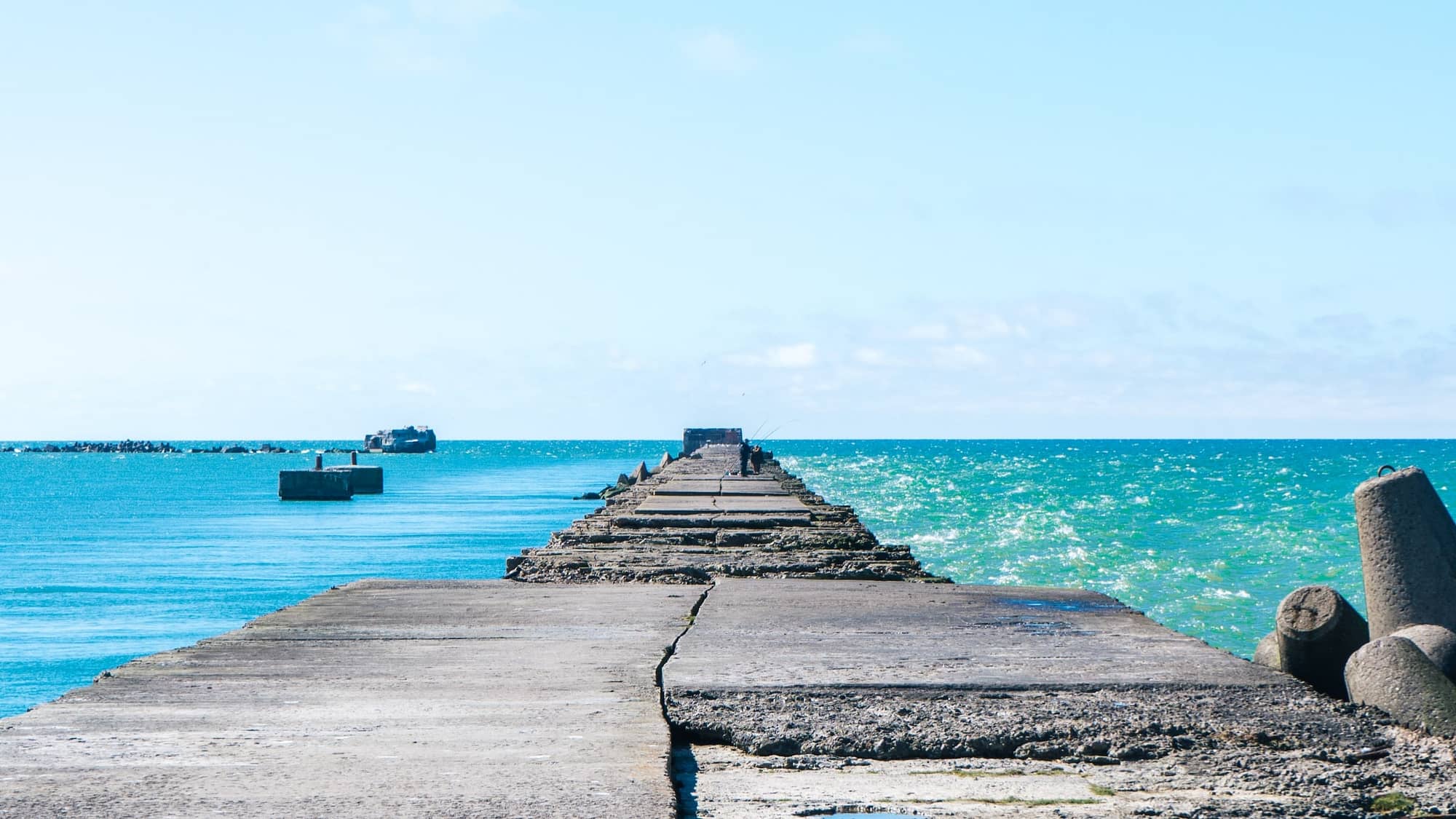 Image: A breakwater, the seas on one side rough, and the other calm, representing our different states of mind when overthinking.