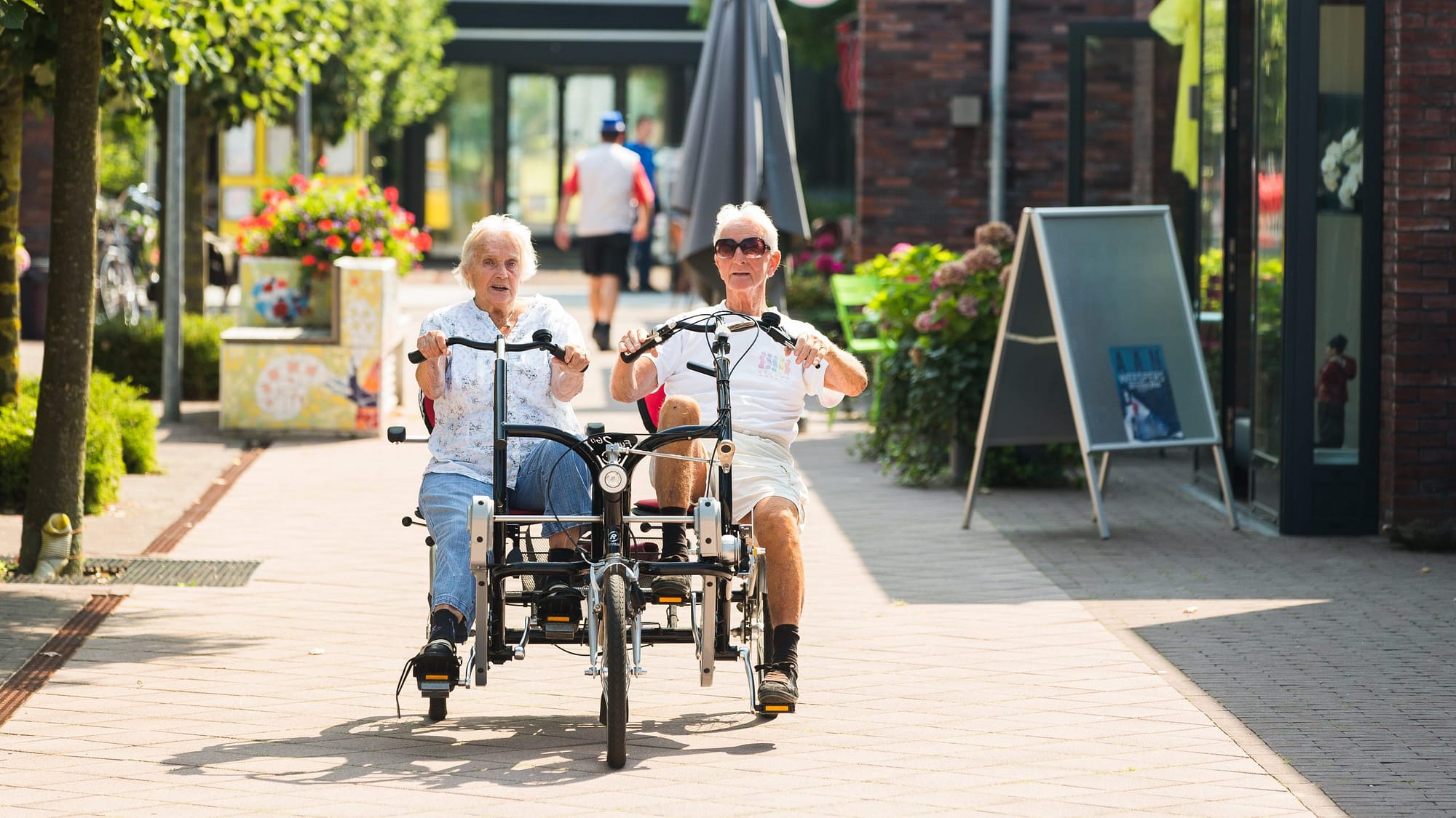 Image: Two residents of Hogeweyk cycling together outside!