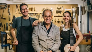 Image: Luthiers team having fun while posing in their family business. Looking at camera