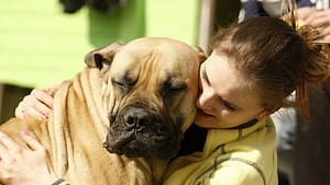 Image: Woman hugs large dog with a smile on his face
