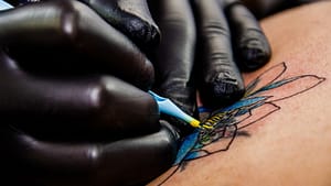 Image: Tattoo artist tattooing a flower