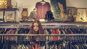 Image: woman sifting through clothing racks at a vintage clothing store