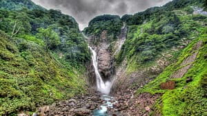 Image: Large waterfall running between two green mountains