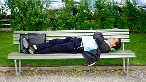 Image: business man sleeps on a park bench