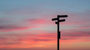 Image: A signpost with a sunset behind