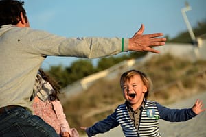 Image: boy runs toward his father's outstretched arms
