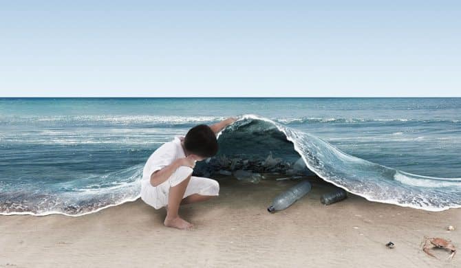 Image: A child pulls back the water on a beach revealing all the plastic garbage