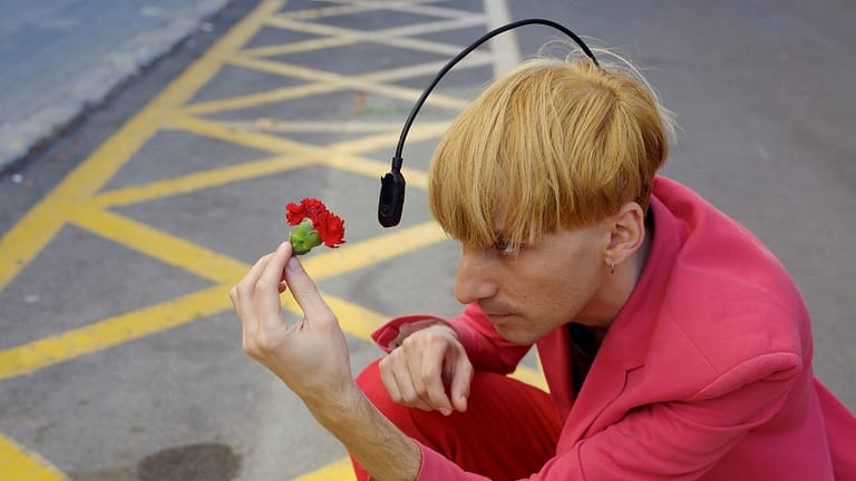 Image: Neil Harbisson using his antenna to "see" the color of the flower he's holding in front of himself