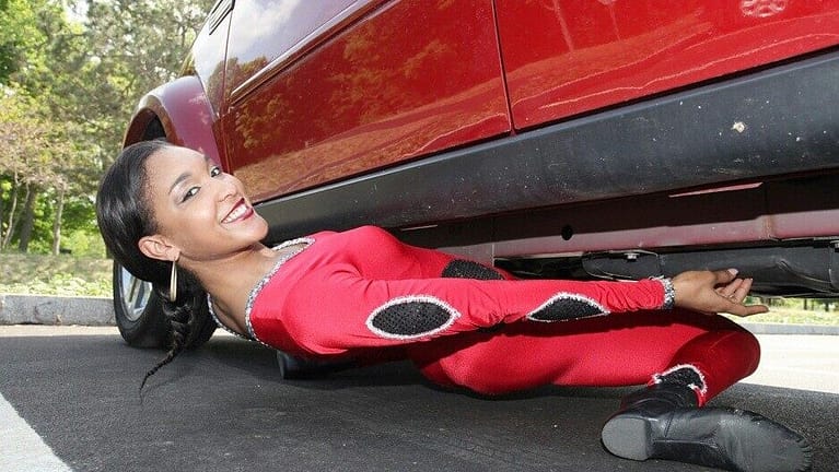 Image: Shemika Charles shimmying under an SUV