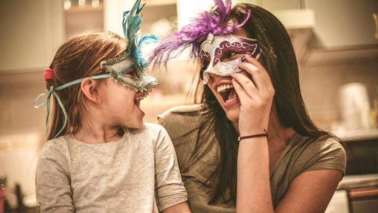 Image: mother and daughter wearing party masks