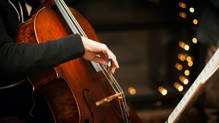 Image: A person playing a cello as part of the Street Symphony program.