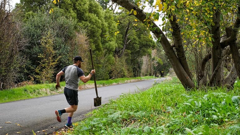 Image: Beau Miles running with a shovel during his mile an hour day
