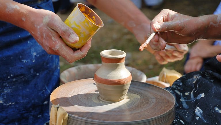 Image: People using their hands to create pottery.