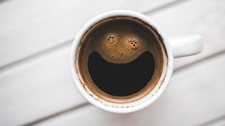Image: Coffee in a mug from the zero waste cafe, the foam swirled to look like a smiling face.