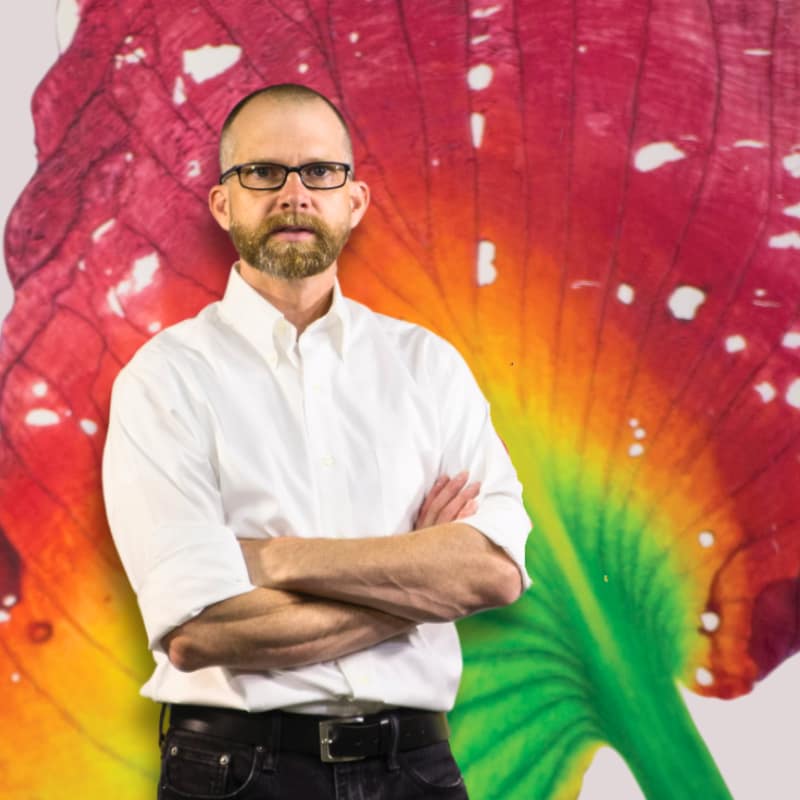 Artist, Activist, and Environmentalist John Sabraw stands in front of art he made with paints that his organization created from toxic runoff.
