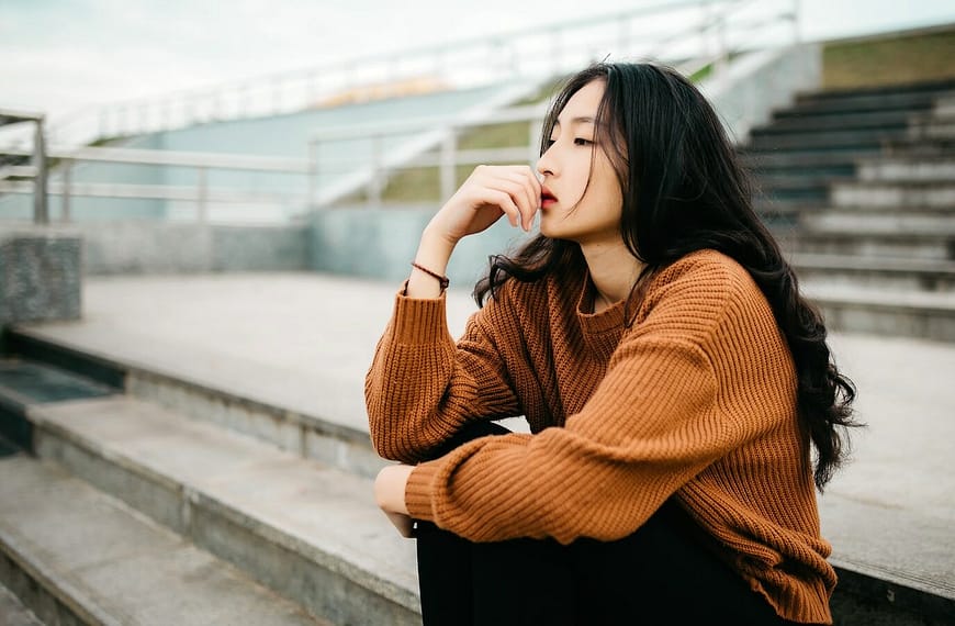 woman wearing brown sweater holding lips