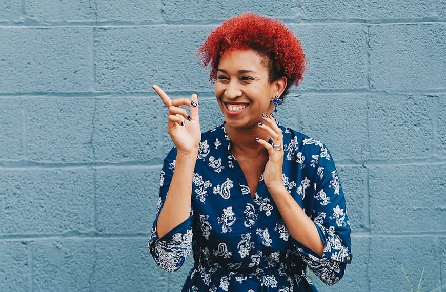 woman smiling while pointing on her right side