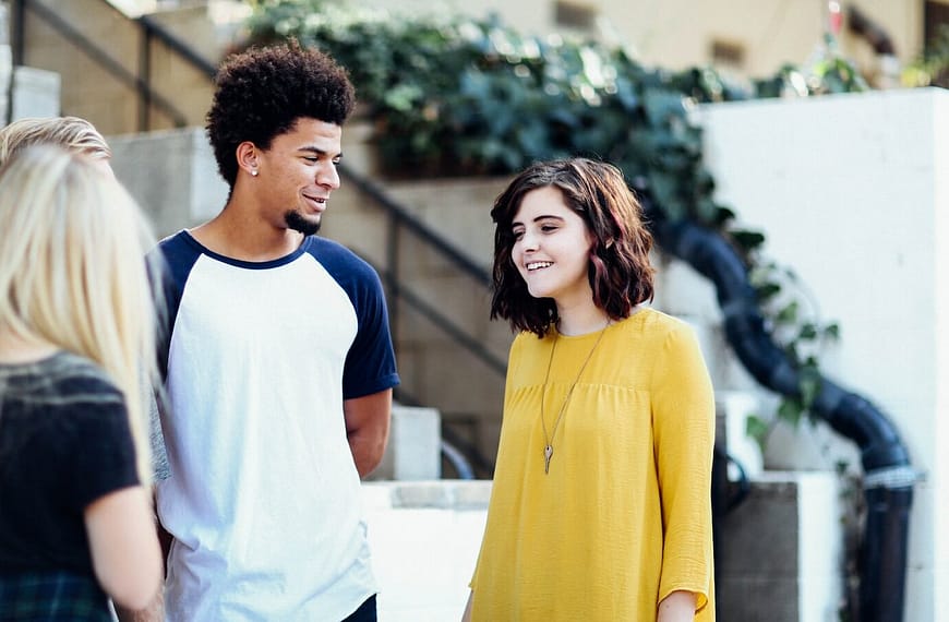 women and man talking outside the building