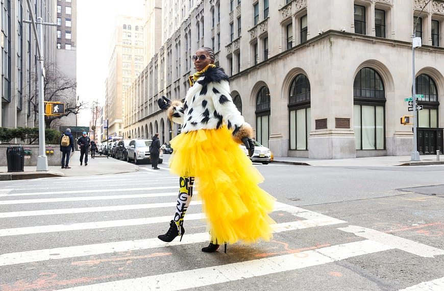 woman wearing yellow and white dress passing on road
