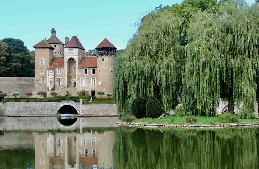Image: castle on the water with willow trees on the bank