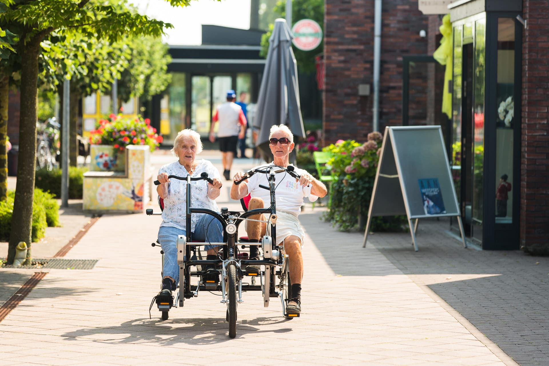 Image: Two residents of Hogeweyk cycling together outside!