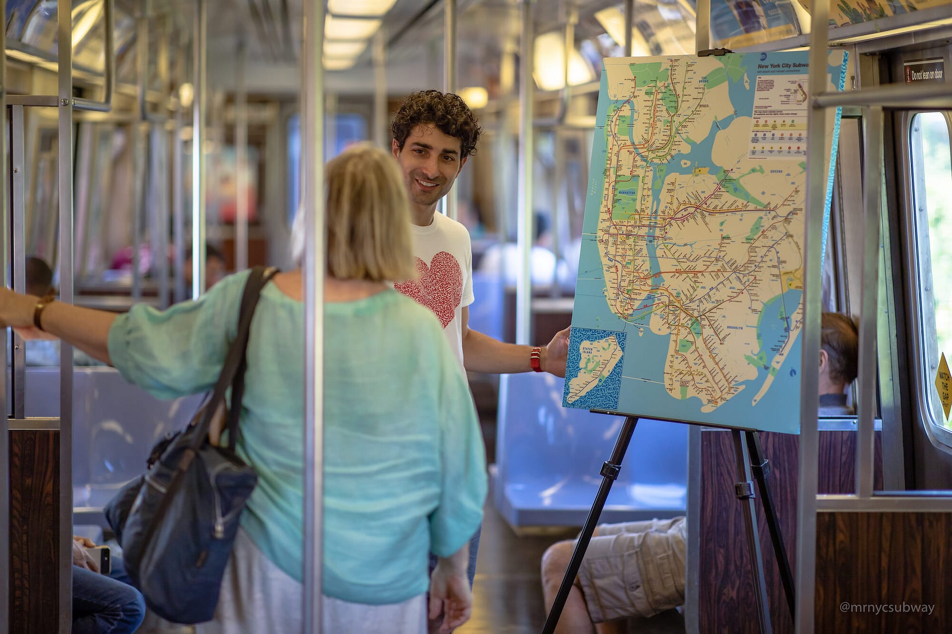 Image: Marco Santini on the NYC subway asking a woman what she loves about New York City