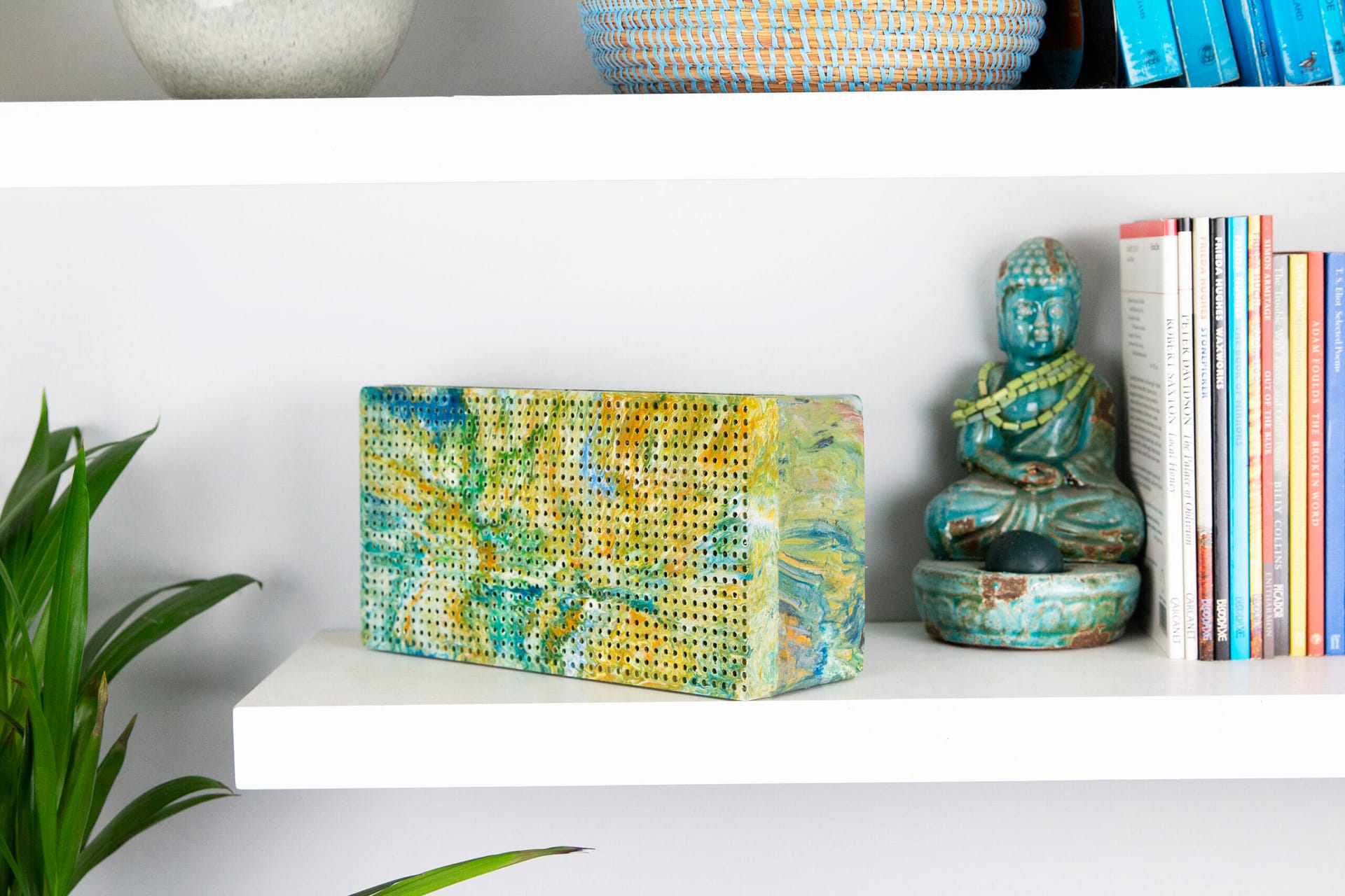 Image: Gomi Designs speaker in bright multicolors on a bookshelf 