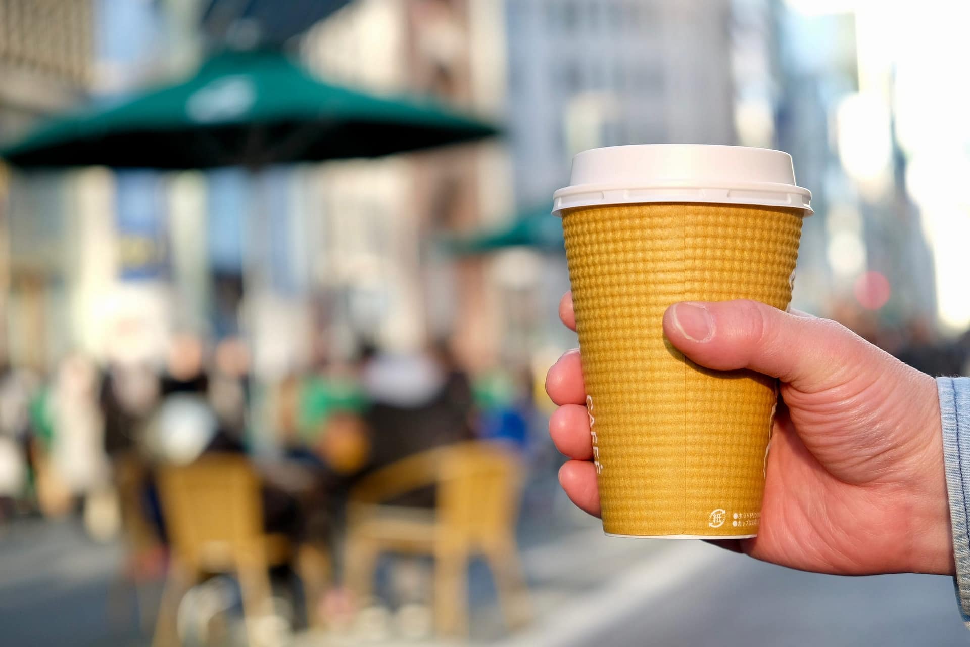 Image: Hand holding a to-go cup of coffee