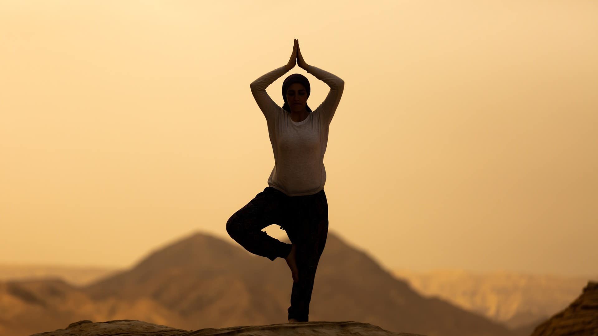 Image: Silhouette of a person in "tree pose"