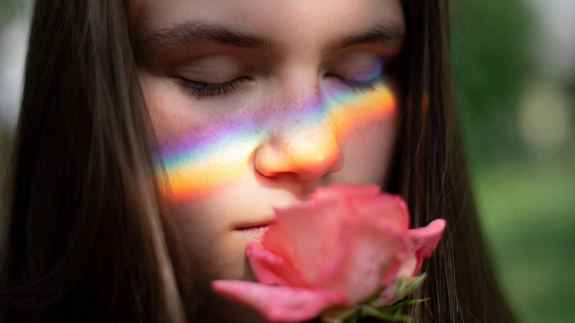 Image: A girl smelling a rose with deep satisfaction